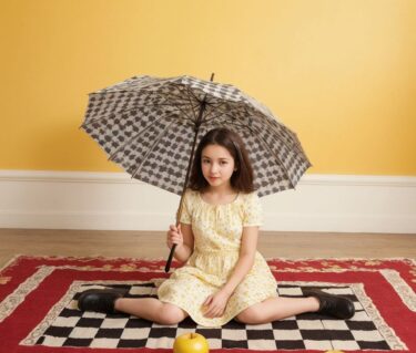 室内で傘を持つ少女：ADHDの創造性と衝動性を表現する遊び心あふれる光景